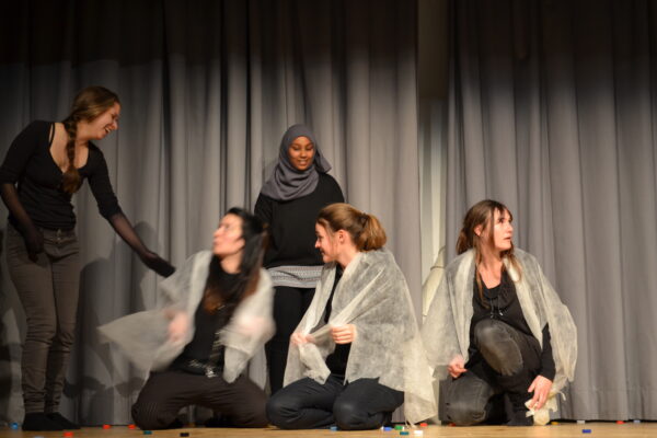 Theaterszene mit fünf Frauen auf der Bühne beim Abschluss eines partizipativen Theaterprojekts